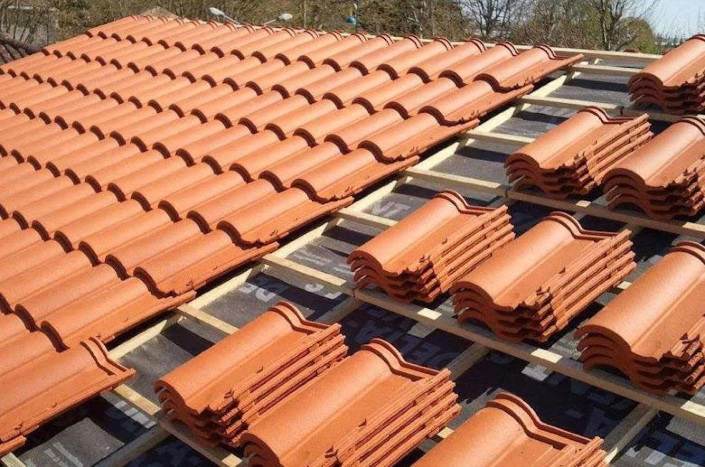 Pose de tuiles neuves sur une toiture aux Pujols, Ariège